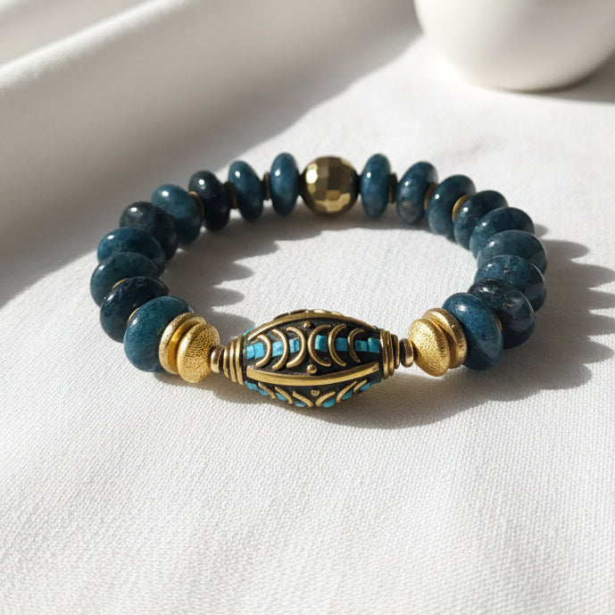 Turquoise beaded bracelet with a gold and blue colored spiral centerpiece