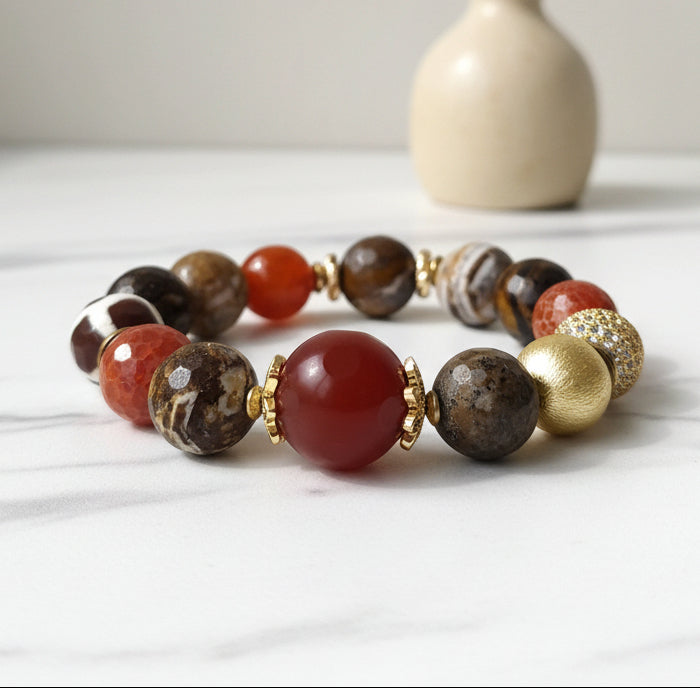 A bracelet with a mix of brown, rust, and white beads, some of which have a glossy finish, displayed against a neutral background.