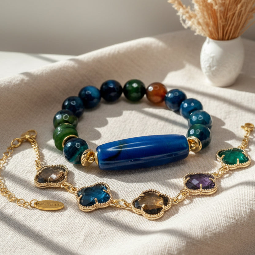 Colorful beaded bracelet and necklace on a light surface with a vase of dried flowers in the background.