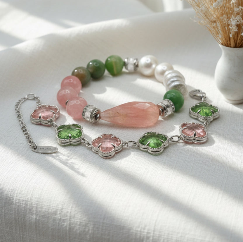Beaded bracelet with pink, green, and silver elements on a light surface.