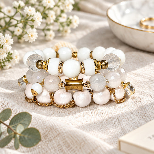 White beaded bracelet with gold accents on a white surface