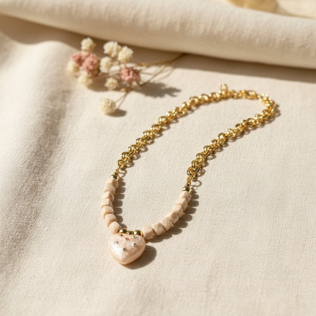 Necklace with gold chain and beige beads on a white background