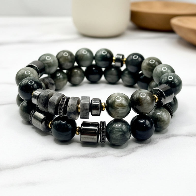 Stack of gray beaded bracelets on a marble surface