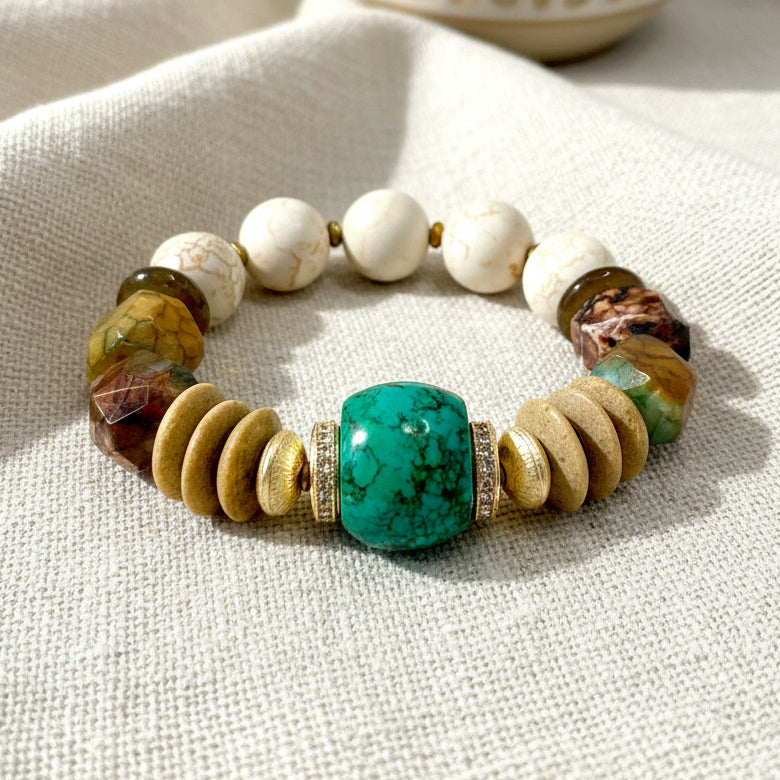 A bracelet with a central turquoise bead, surrounded by beige and multicolored beads, displayed against a neutral background.