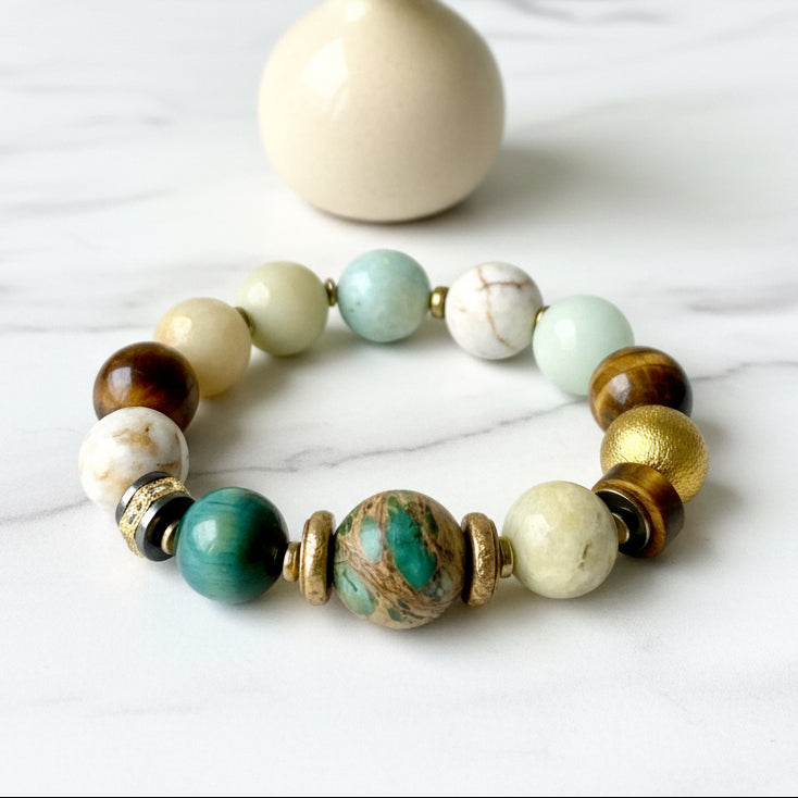 A multicolored beaded bracelet with gold-tone accents, displayed against a neutral background.