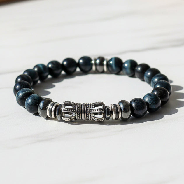 Blue Tiger Eye beaded bracelet with a silver centerpiece on a white background