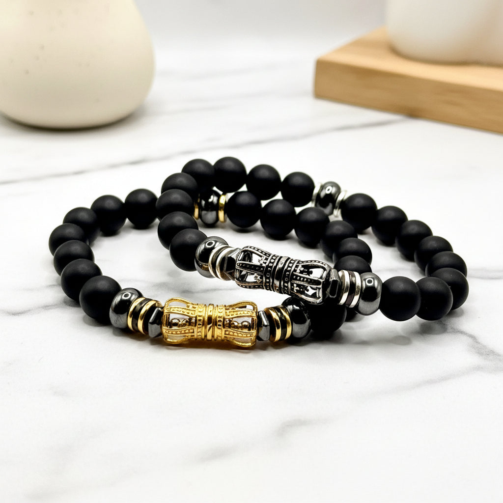 Black beaded bracelet with gold and silver accents on a white background