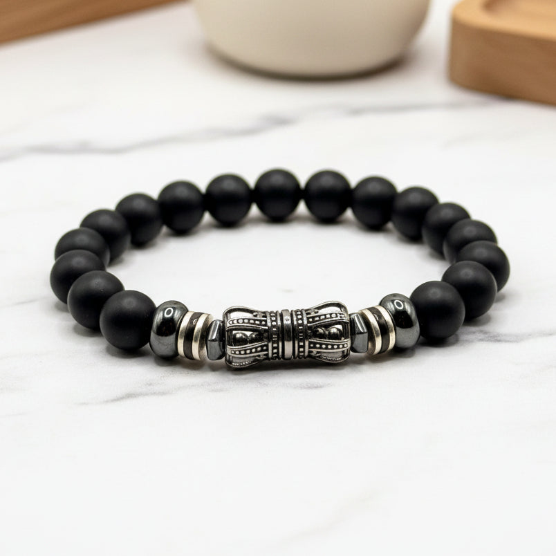 Black beaded bracelet with a silver clasp on a white background