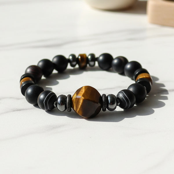 Black striped Agate beaded men's bracelet with Tiger Eye centerpiece on a white background