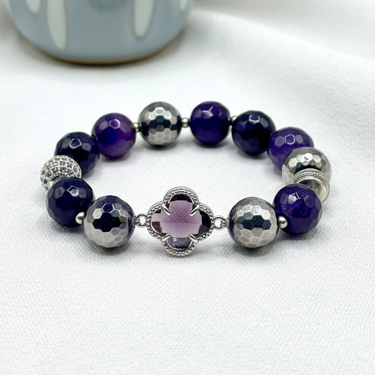 Beaded bracelet with purple and silver beads on a white background