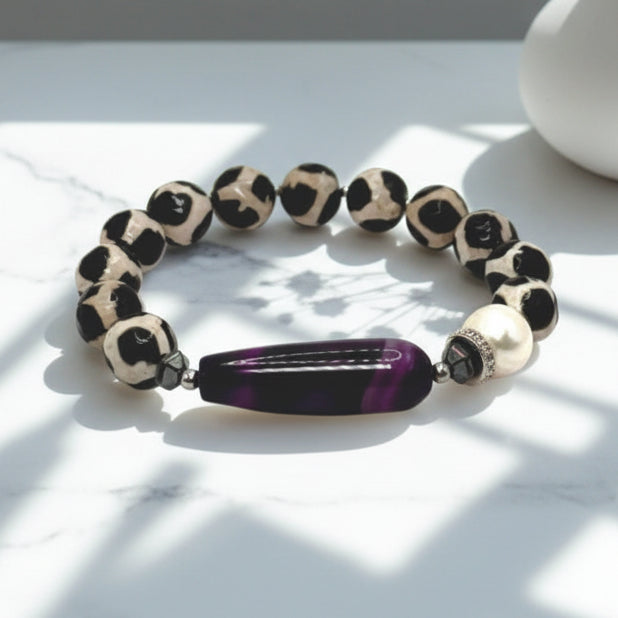 Beaded bracelet with leopard print and purple accent on a light surface