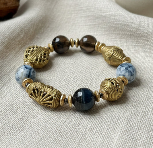 Beaded bracelet with gold and blue beads on a dark surface