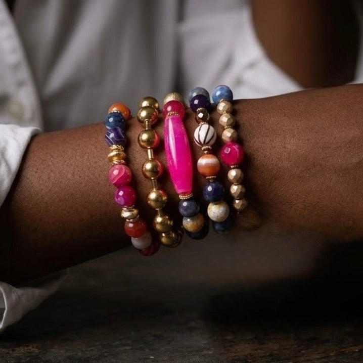 Multicolored beaded bracelets on a wrist with a blurred background