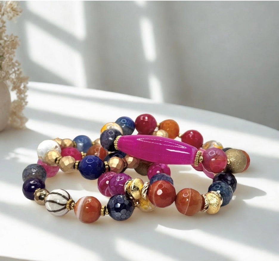 Colorful beaded bracelet with a pink accent on a white surface