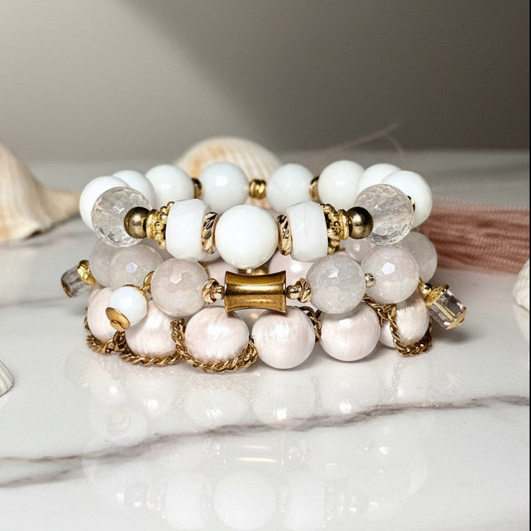 White beaded bracelet with gold accents on a white surface