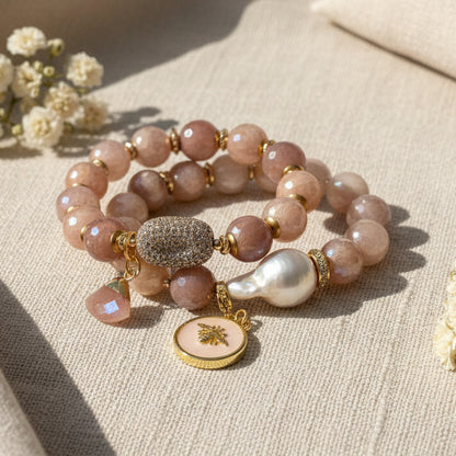 Beaded bracelet with gold accents and charms on a white background