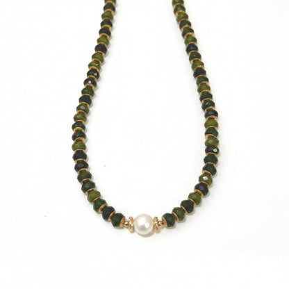 Necklace with olive green beads and a pearl pendant on a white background