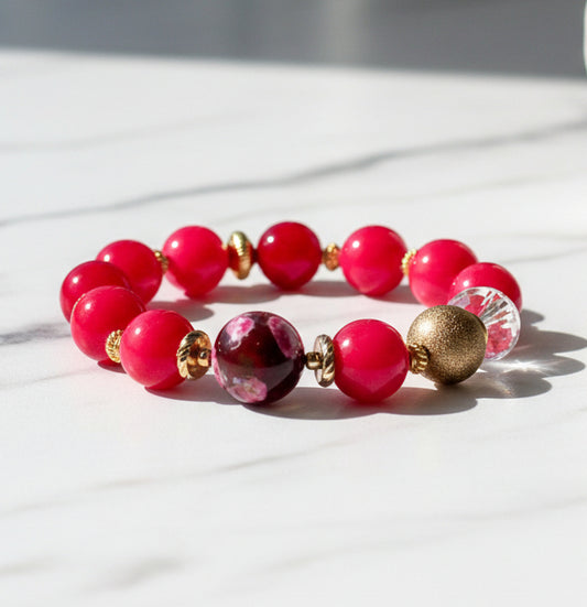 Beaded bracelet with pink and gold beads on a white background