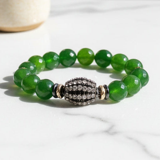 Green beaded bracelet with a decorative clasp on a white background