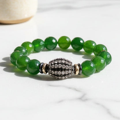 Green beaded bracelet with a decorative clasp on a white background