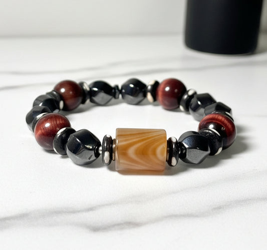 Beaded bracelet with brown, black, and beige beads on a white background