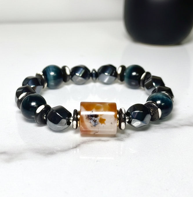 Bracelet with navy blue beads and a marble agate centerpiece on a white background