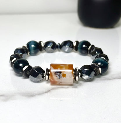 Bracelet with navy blue beads and a marble agate centerpiece on a white background