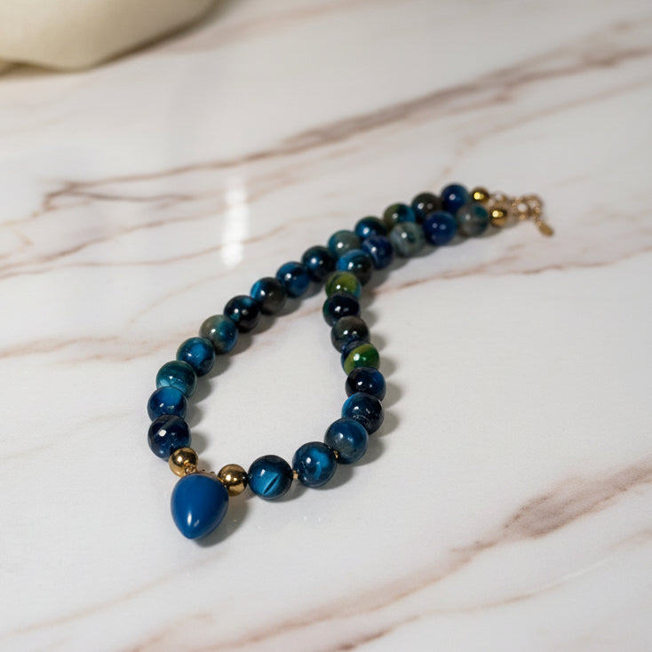 Beaded necklace with blue and gold accents on a white surface
