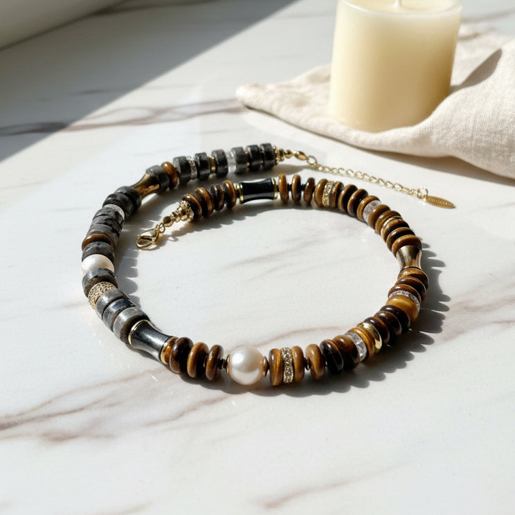 Labradorite and tiger's eye necklace accented with gold and pearls on a white background