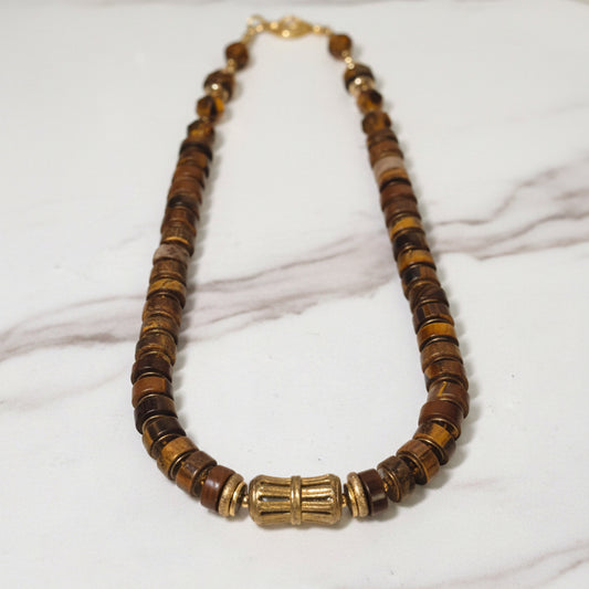 Necklace with brown and gold beads on a white background