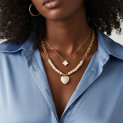 Gold necklace with heart pendant on a black female model 
against a neutral background