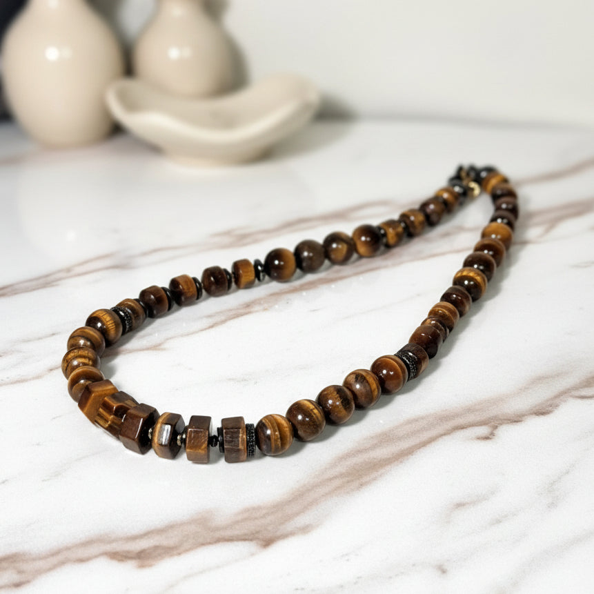 Beaded necklace with brown and black beads on a white surface