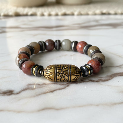 Multicolored beaded bracelet with a gold accent on a white background