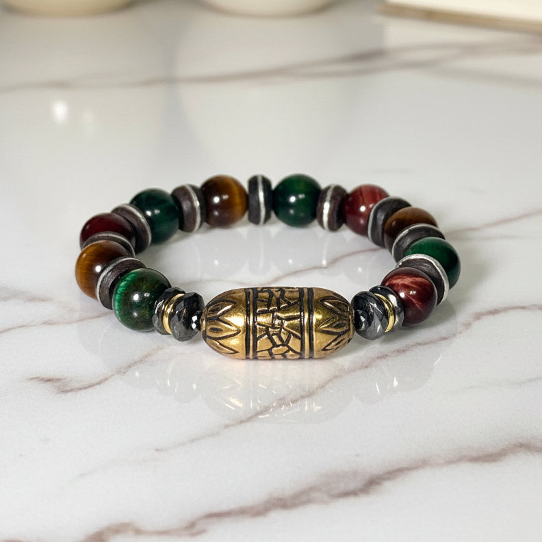 Multicolored beaded bracelet with a gold and bronze focal bead on a white background