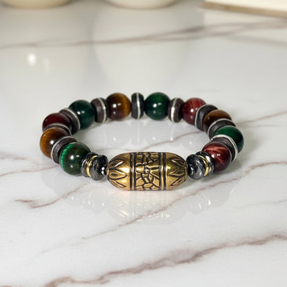 Multicolored beaded bracelet with a gold and bronze focal bead on a white background