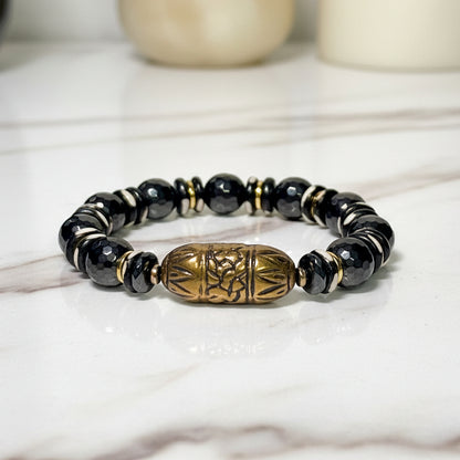 Black beaded bracelet with a gold accent on a white background