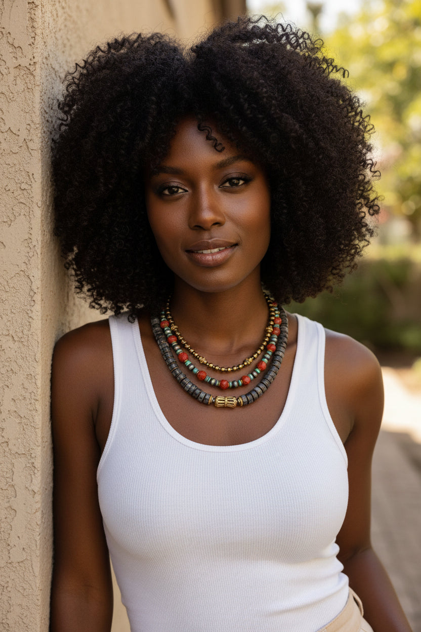 Layered gemstone necklaces on a black model wearing a white tanlk