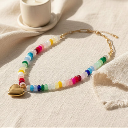 Necklace with colorful beads and a gold heart pendant on a white background