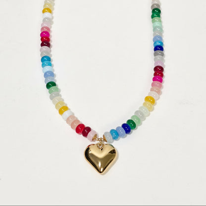 Necklace with multicolored beads and a gold heart pendant on a white background