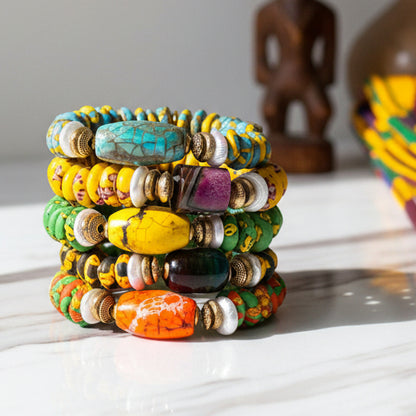 Stack of colorful beaded bracelets on a light gray background