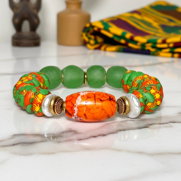 Bracelet with green, orange, and gold beads on a white background