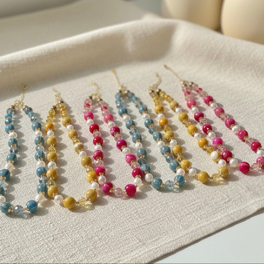 Set of colorful beaded necklaces on a light fabric surface