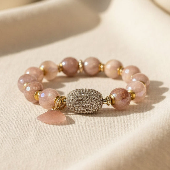 Bracelet with peach beads and a peach pave centerpiece on a linen background