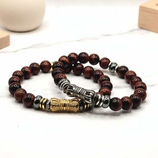 Beaded bracelet with gold, silver, and black beads on a white background