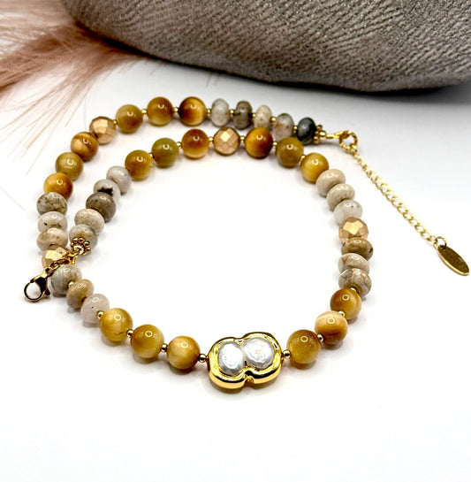 Full front view of beaded necklace with gold tiger eye and jasper beads with focus on pearl centerpiece.